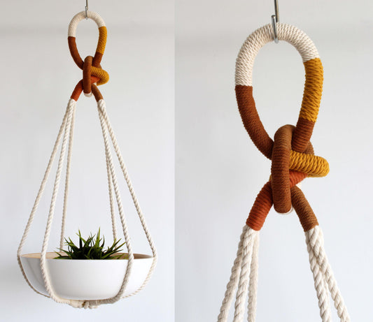 A macrame plant hanger shown in two views against a plain white background. The hanger features a cream-colored rope loop and hanging cords with a geometric pattern of white, rust orange, and mustard yellow.