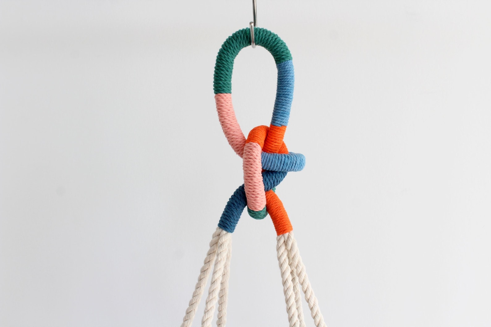 Tassel-free macrame plant hanger with colorful wrapped top loop knot holding a white ceramic bowl by Freefille